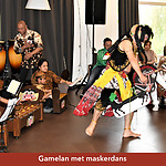 Gamelan begeleidt een maskerdans, dansende mannen met aapmasker